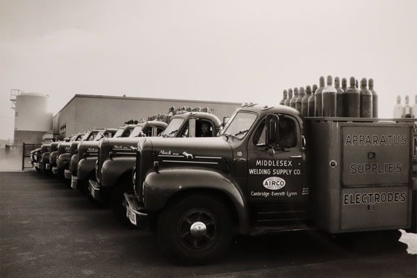 Image of trucks from the 1950s holding gas tanks