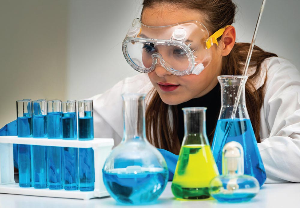 A photo of a female scientist with beakers